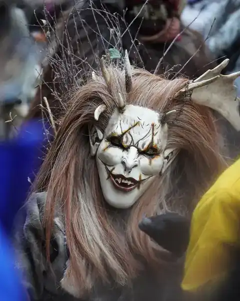 Eine Krampusfigur mit Hörnern und Fellkostüm bei einem Winterumzug