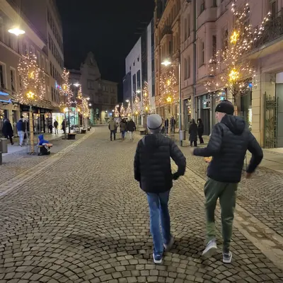 Noah and Elijah walking down a cobbled street strung with Christmas lights in Rosenheim