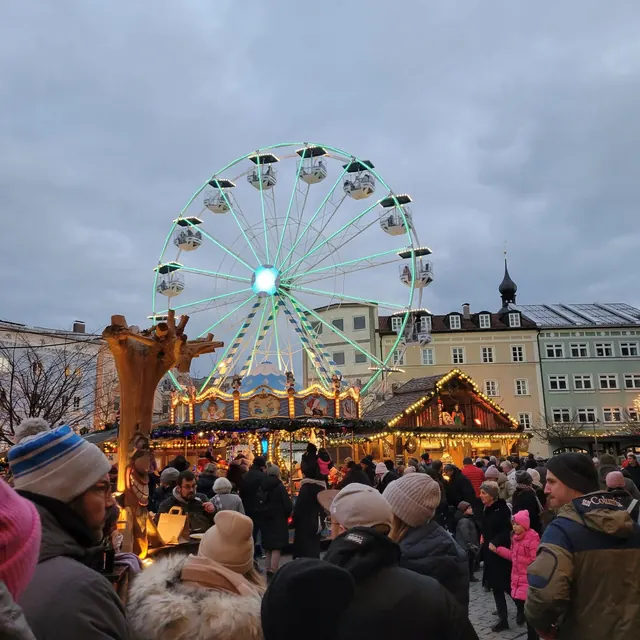 Ferris wheel lit up above the stalls at the Rosenheim Christkindlmarkt