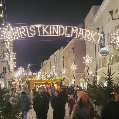 Lit Christkindlmarkt sign over a shopping street in Rosenheim at night