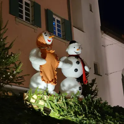 Two big snowman figures decorating a stall at the Rosenheim Christmas market