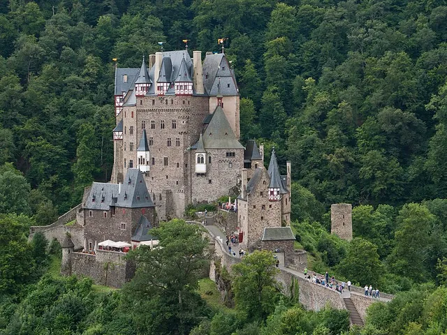 El castillo de Eltz, con sus torres y pisos de entramado de madera, sobre una roca en un valle boscoso