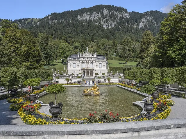 El palacio de Linderhof con su estanque con fuente y jardines en terrazas en un valle de montaña