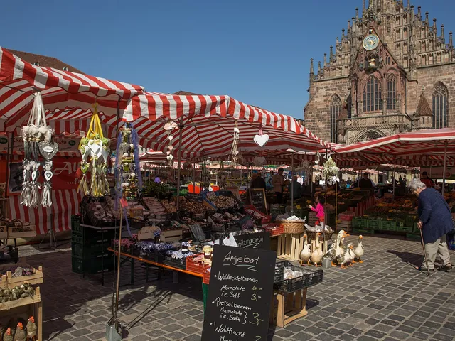 Marktstände mit rot-weißen Dächern auf dem Nürnberger Hauptmarkt vor der Frauenkirche